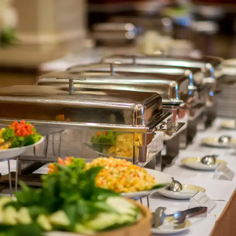 Bandejas calientes de acero para buffet con ensaladas y acompañamientos al frente
