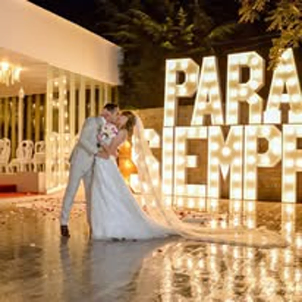 Pareja frente a letras PARA SIEMPRE iluminadas en La Mansion Francesa